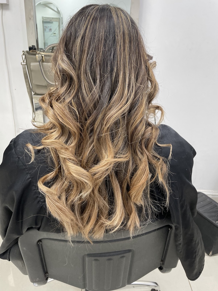 Long balayage hair with soft caramel curls styled at Laiba