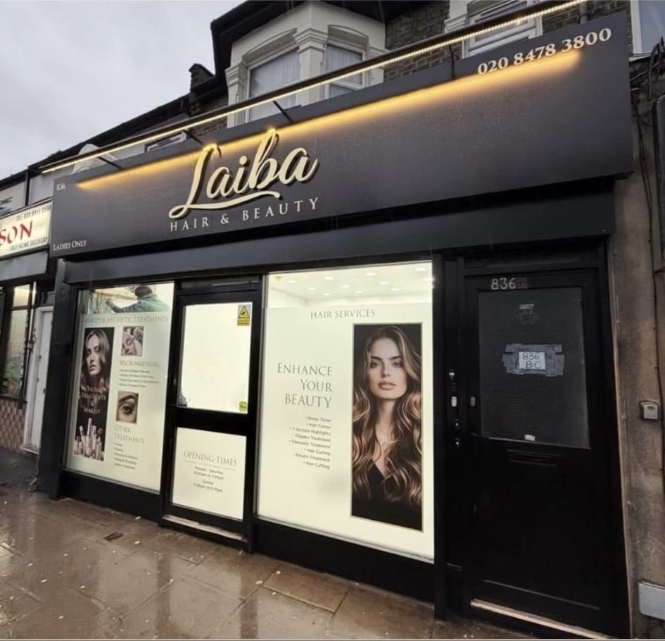 The Laiba Hair & Beauty shopfront at 836 Romford Road, Manor Park — a black fascia with a gold script sign, warmly lit